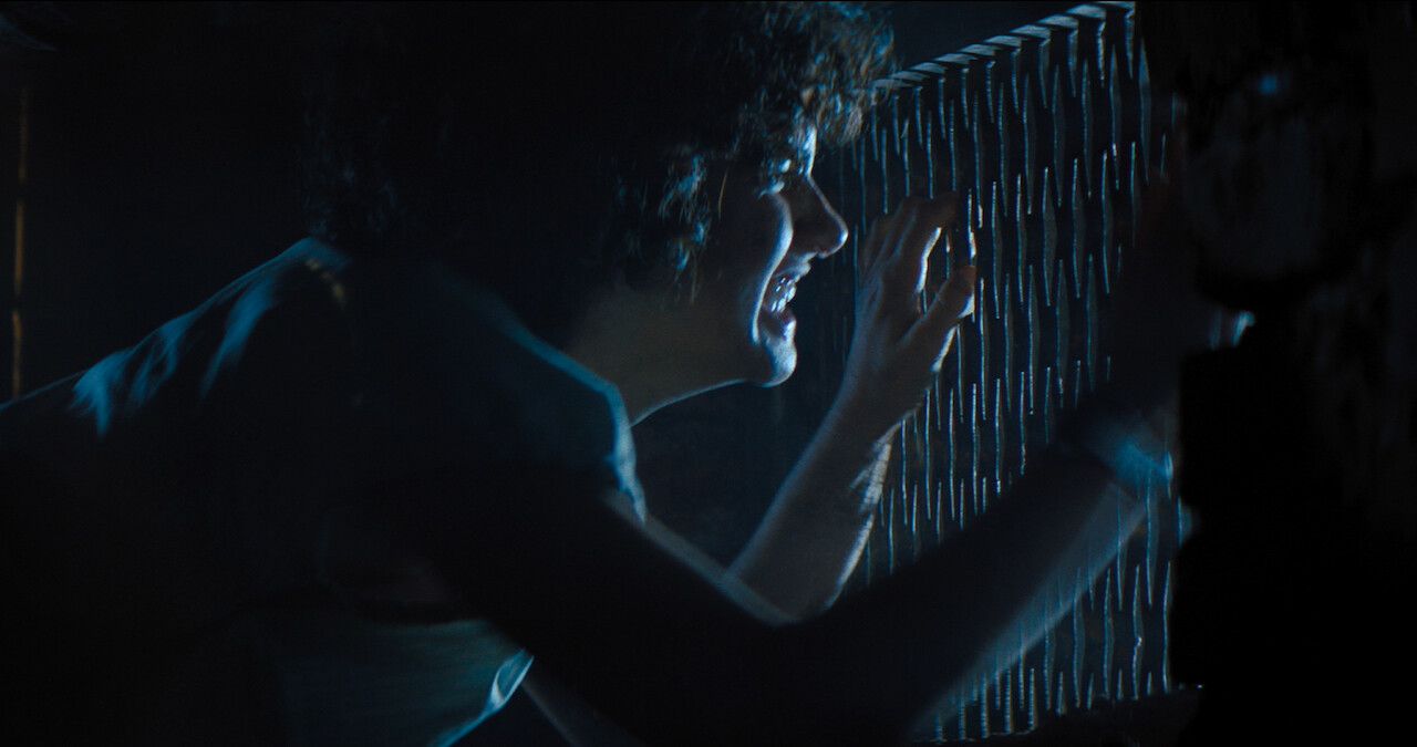 A terrified Melody peeks through a grate to get away