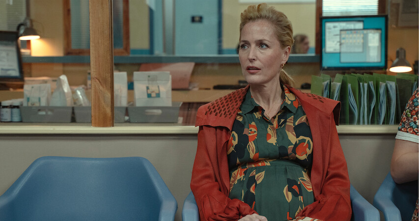 Gillian Anderson as Jean Milburn sits in the waiting room of a doctor's office while pregnant in Season 3 of ‘Sex Education.’