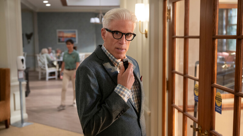 Ted Danson walks through a wallpapered hallway touching spyglasses on his face in Season 1 of 'A Man on the Inside'