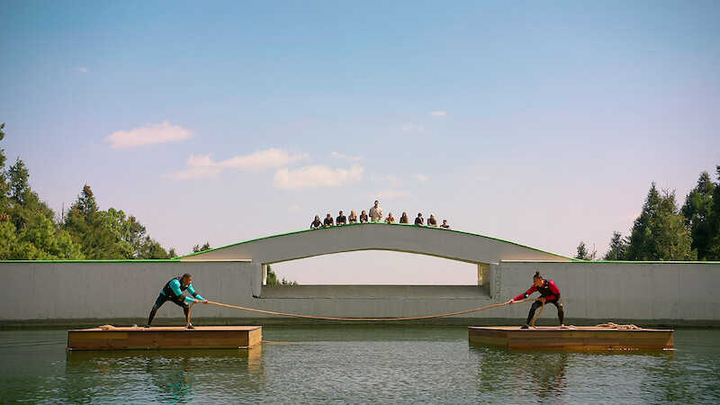 Players compete in a tug of war challenge on the water in 'Battle Camp'