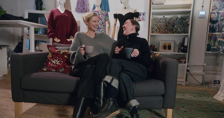 Cast sitting down on a green couch