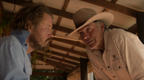 Two men in a barn intensely look at each other in Season 1 of 'Territory'