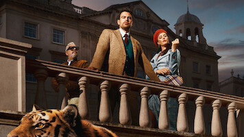 Three stylish people stand on a grand stone balcony in front of an elegant building at dusk, with a tiger at the bottom of the image, creating a dramatic and luxurious atmosphere.