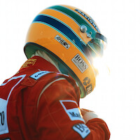 Ayrton Senna (Gabriel Leone) wears a red Marlboro jacket and a green-and-yellow helmet as he gears up to race.