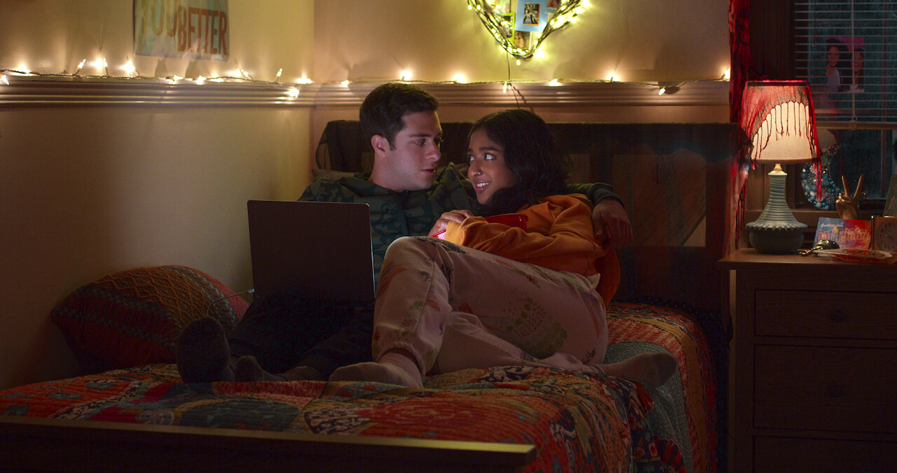 Jaren Lewison as Ben Gross and Maitreyi Ramakrishnan as Devi in Never Have I Ever Season 4 sitting on college dorm bed.