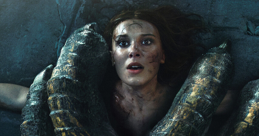 Millie Bobby Brown as Princess Elodie in distress in a forest.