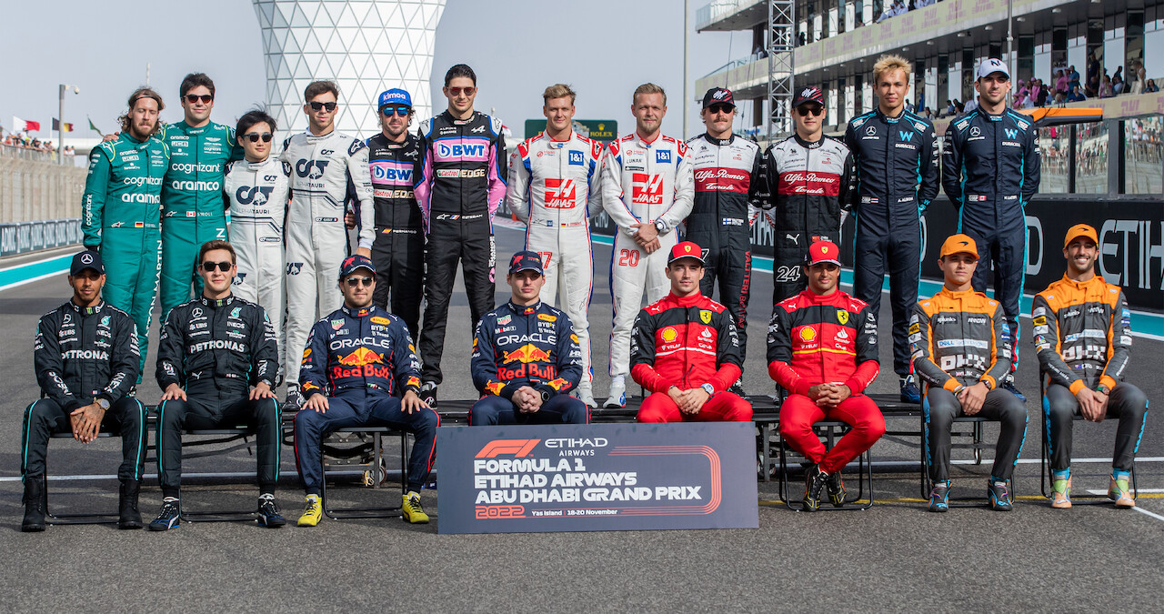 Formula 1 race car drivers pose for a photo with Abu Dhabi Grand Prix sign