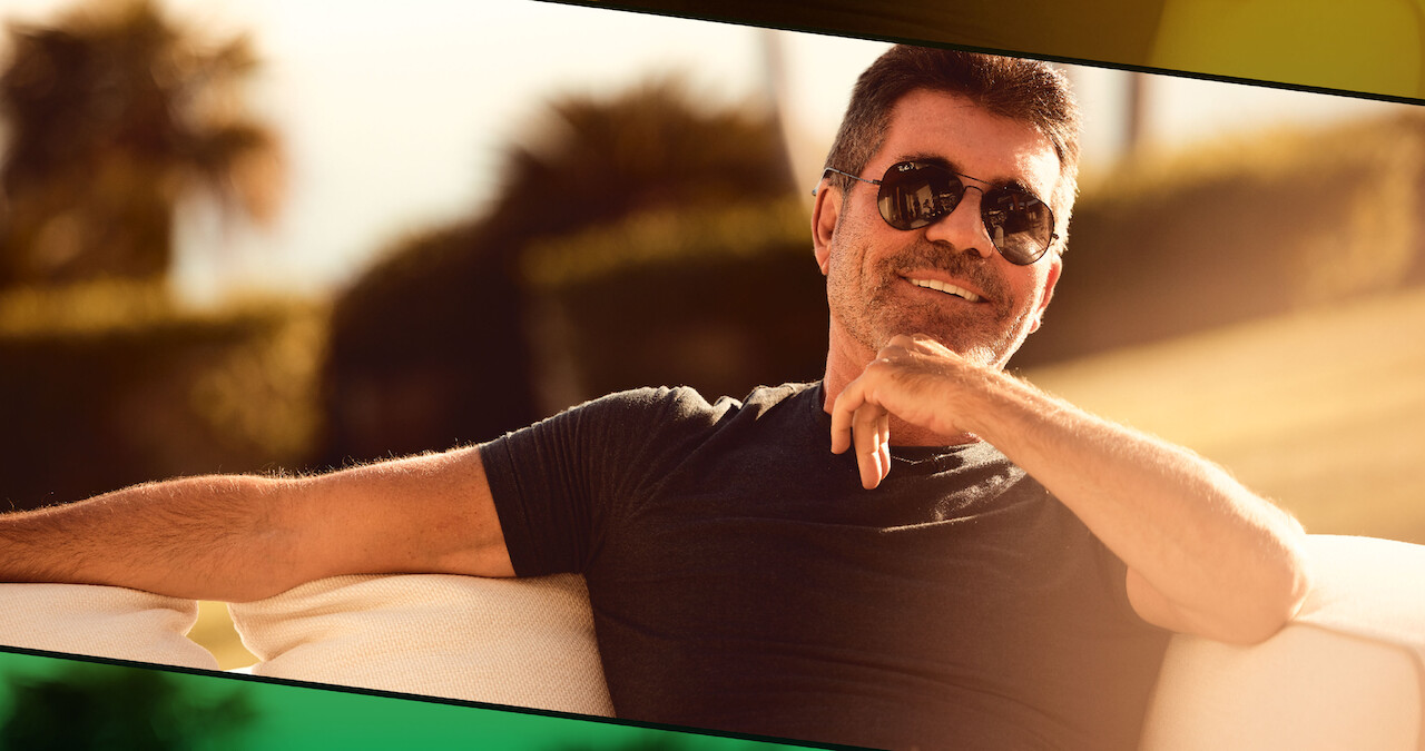 Simon Cowell sitting outdoors.