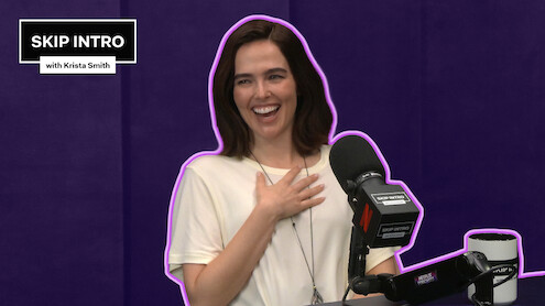Zoey Deutch sits smiling and laughing in front of a microphone during a podcast recording for "Skip Intro with Krista Smith." The background is purple, and the podcast logo appears in the top left corner.