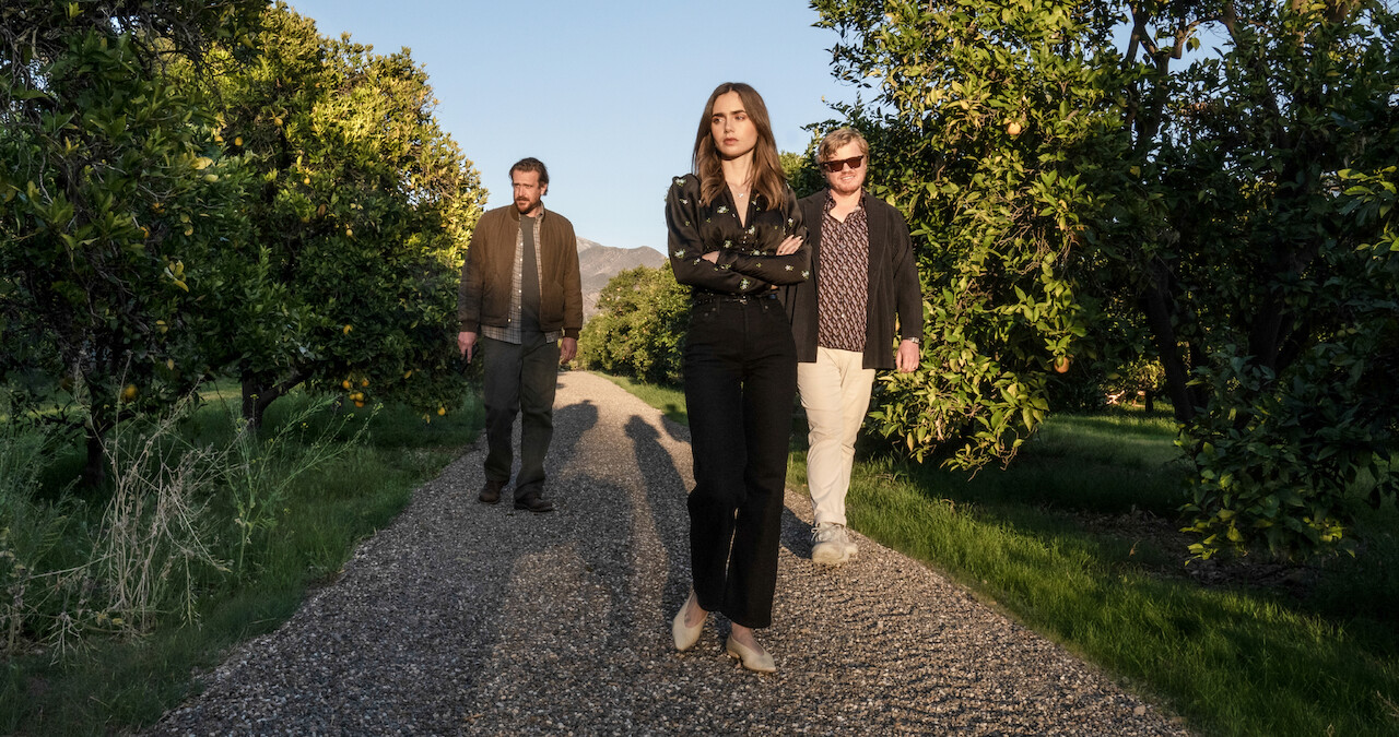 Lily Collins and others walking amid orange groves in the film 'Windfall'