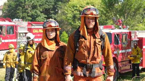 Stephanie Arcila as Gabriela Perez and Max Thieriot as Bode Donovan wear firefighting gear in 'Fire Country'