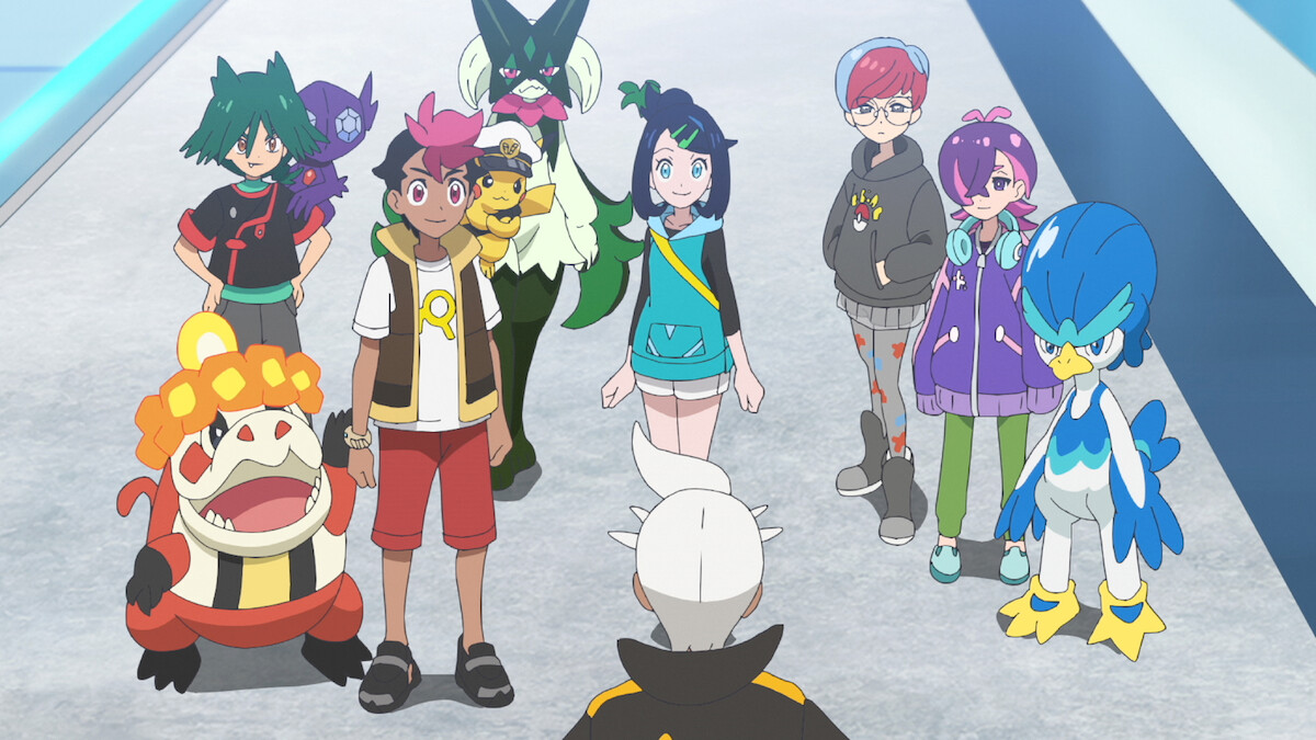 A group of animated characters and their Pokémon stand indoors on a wide walkway, facing an adult with white hair from behind, suggesting a meeting or conversation in a bright, modern environment.