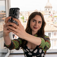 Lily Collins como Emily tira uma selfie na temporada 4 de ‘Emily em Paris’