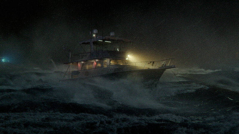 A fishing boat struggles in rough, stormy seas at night, illuminated by onboard lights while waves crash around it, creating a dramatic and tense maritime scene.