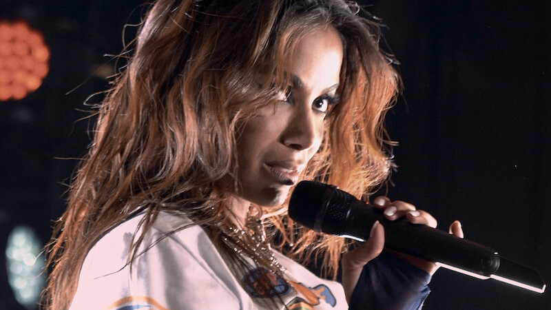 Anitta holding a mic during a performance