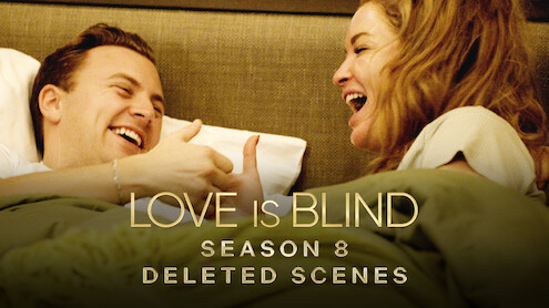 Daniel and Taylor are laughing and engaging in a playful thumb wrestling match while relaxing in bed together.