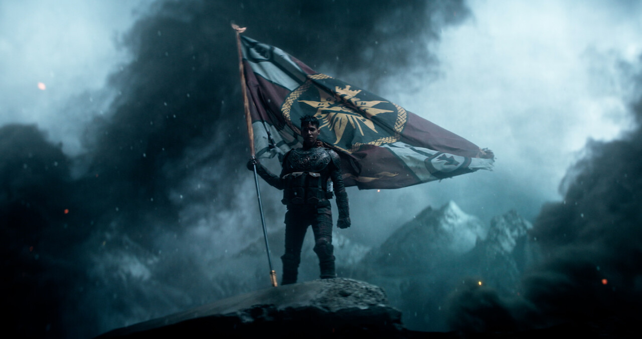 A person holding a flag surrounded by smoke 
