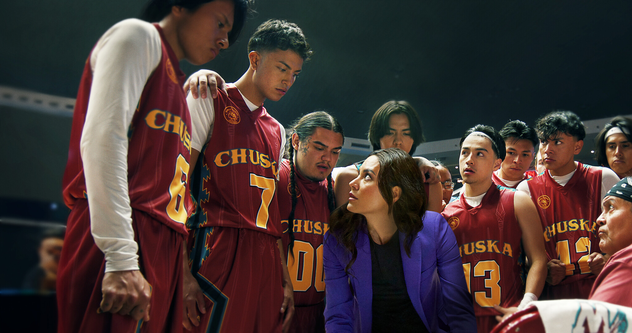 The characters of Rez Ball in a huddle around their coach during a game. 