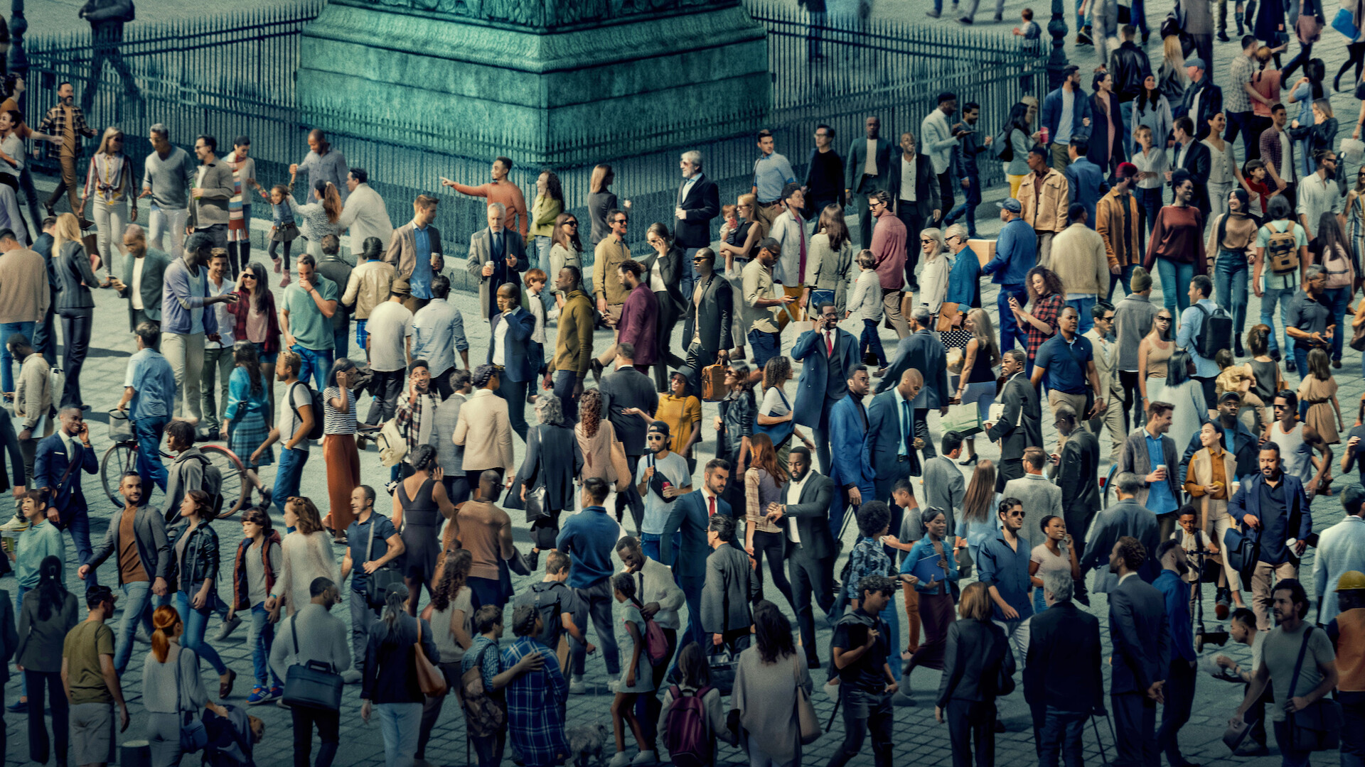 Large crowd of people gathered outdoors in a city square, walking and standing near a monument base on a sunny day, wearing casual and business clothes, creating a busy urban atmosphere.