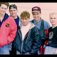 Five members of a boy band smiling