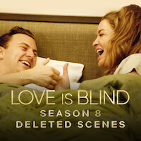 Daniel and Taylor are laughing and engaging in a playful thumb wrestling match while relaxing in bed together.