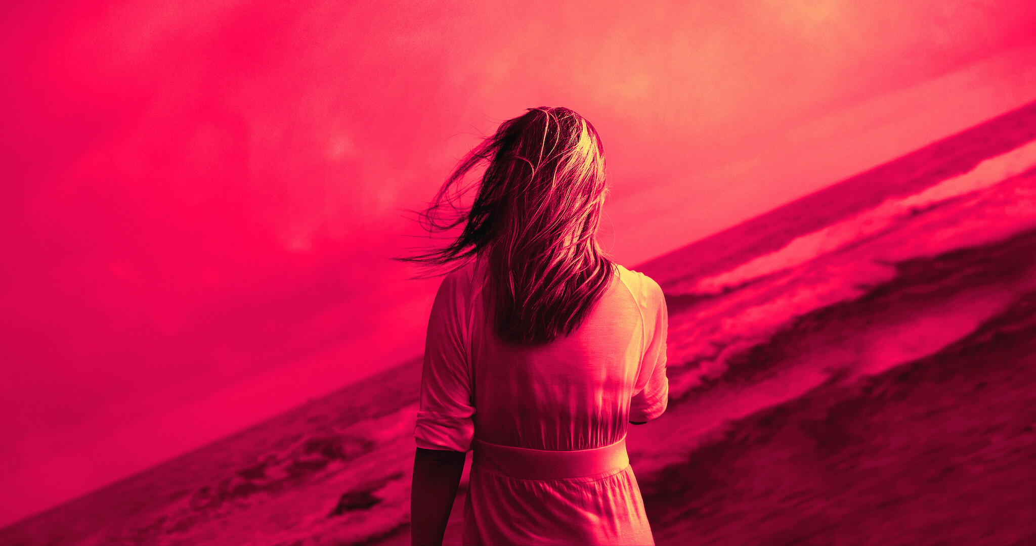 A woman standing with her back to the camera, surrounded by red