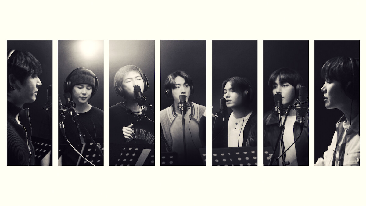 Seven people in a recording studio, each standing at a microphone with music stands, singing or speaking, black and white, portrait orientation, individual spotlight on each person, professional, creative environment.