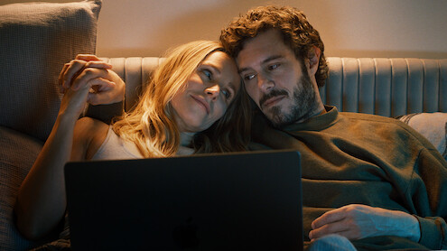 Kristen Bell as Joanne and Adam Brody as Noah snuggle on a couch together in Season 1 of 'Nobody Wants This'