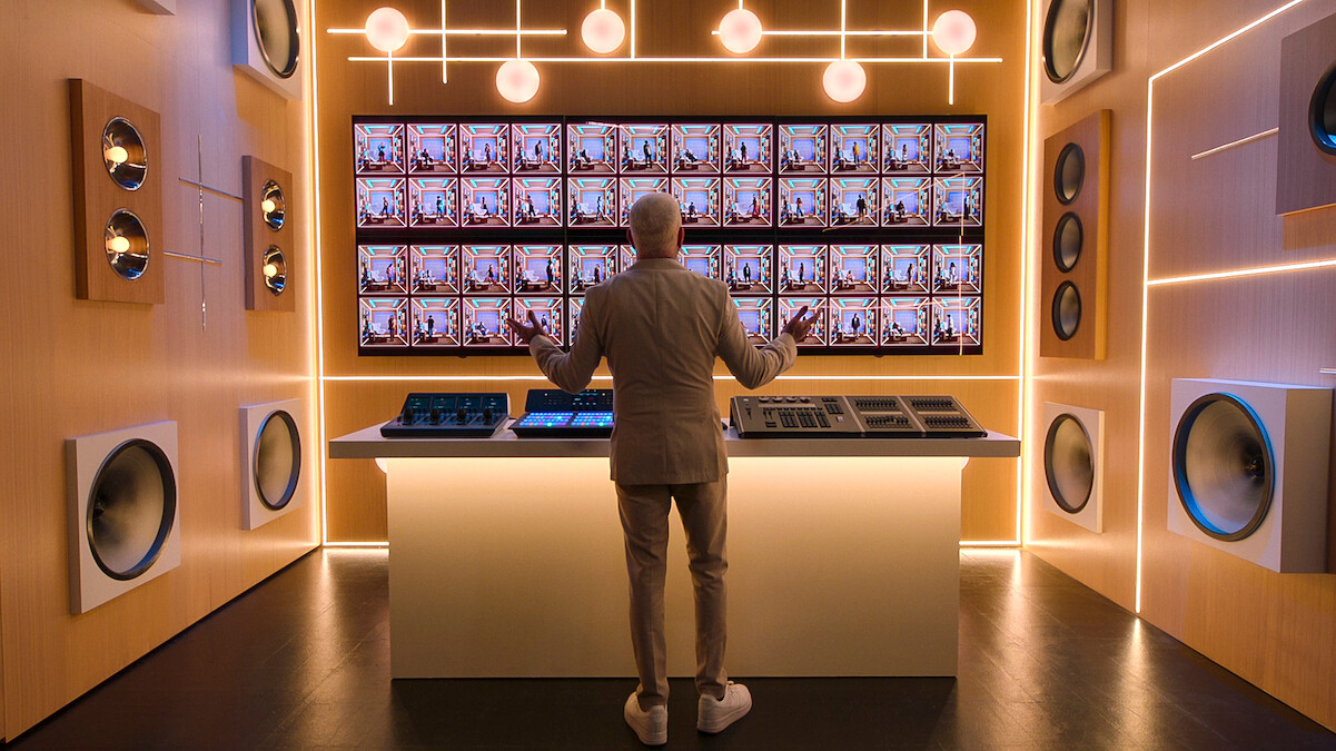 AJ McLean stands in front of a screen featuring the 'Building the Band' Season 1 booths.